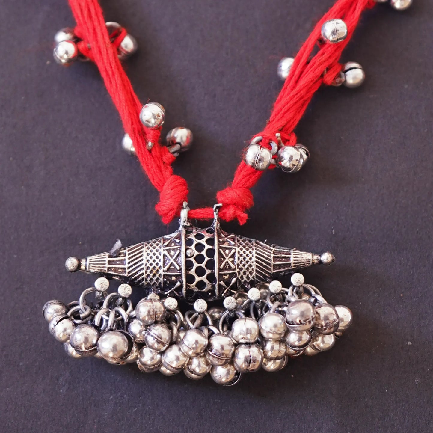 Vibrant Red Thread Neckpiece with Silver Bell Beads and Oval Pendant