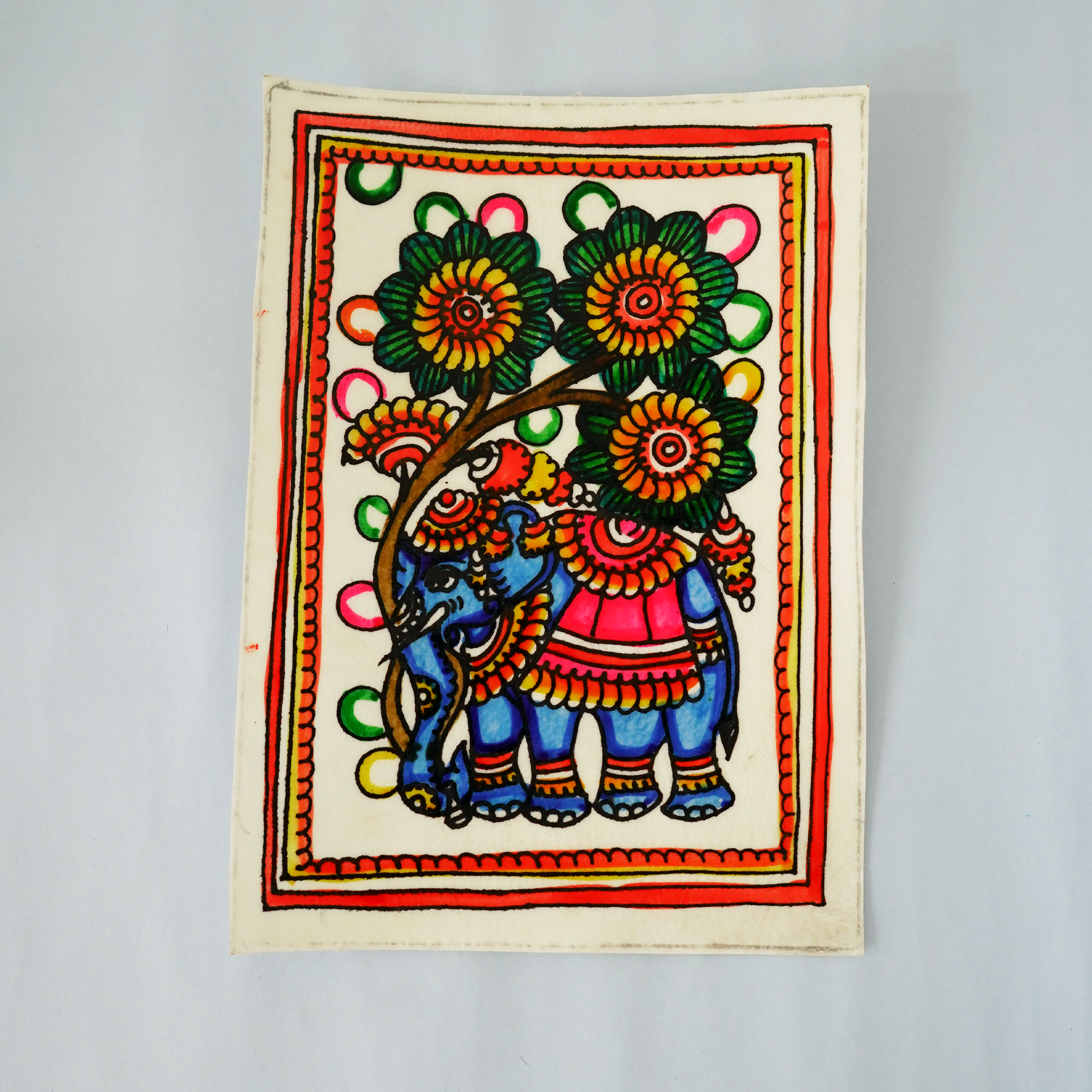 Colorful artwork of an elephant and flowers on a plain background