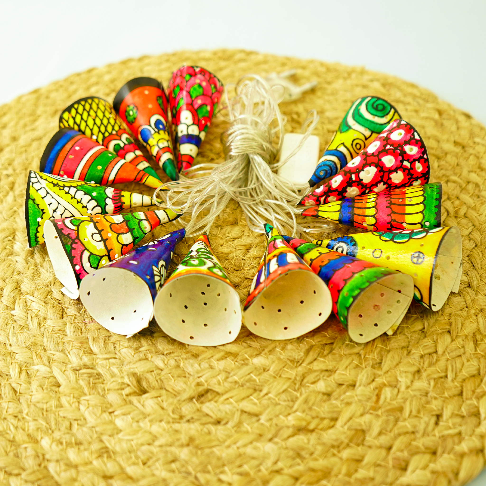 Colorful party hats and a string of lights on a woven surface