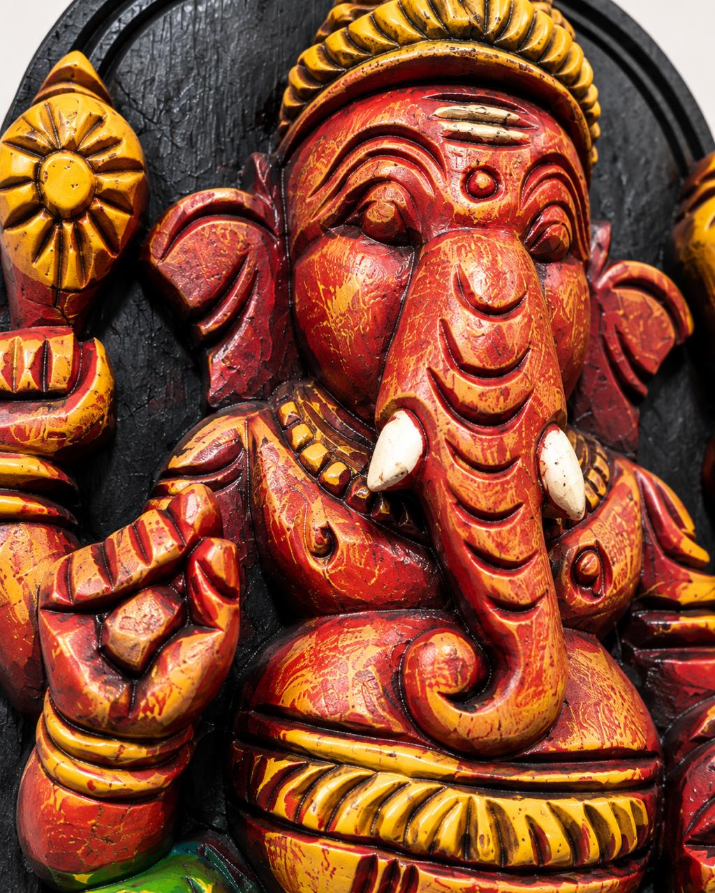 Hand-carved painted Ganesha wooden sculpture seated on a lotus
